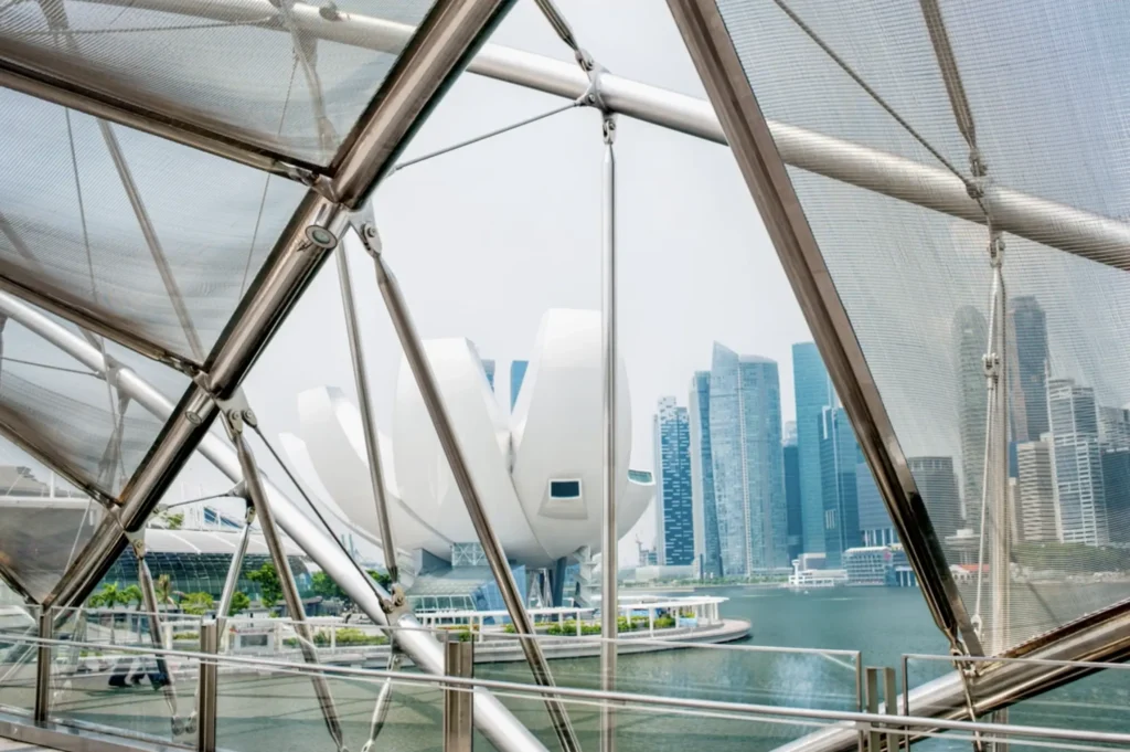 Cityscape view framed by steel beams and glass structure.