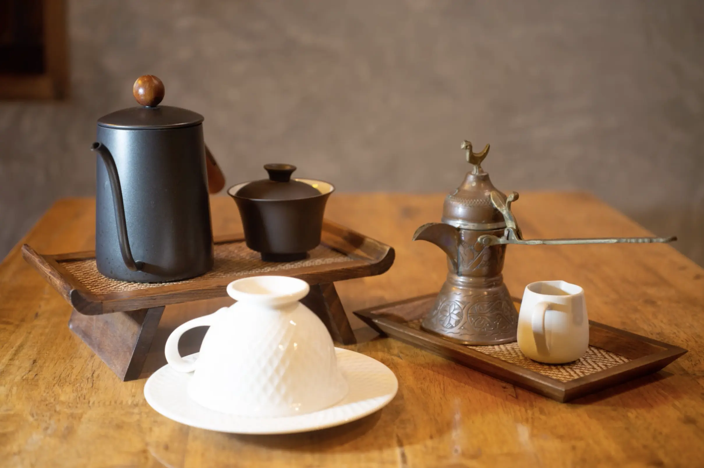 Coffee set with cups and kettles on a wooden table.