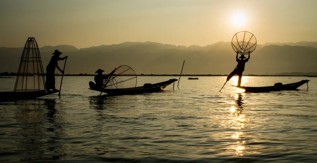 Silhouetted fishermen at sunset. Extreme scene dynamic range.