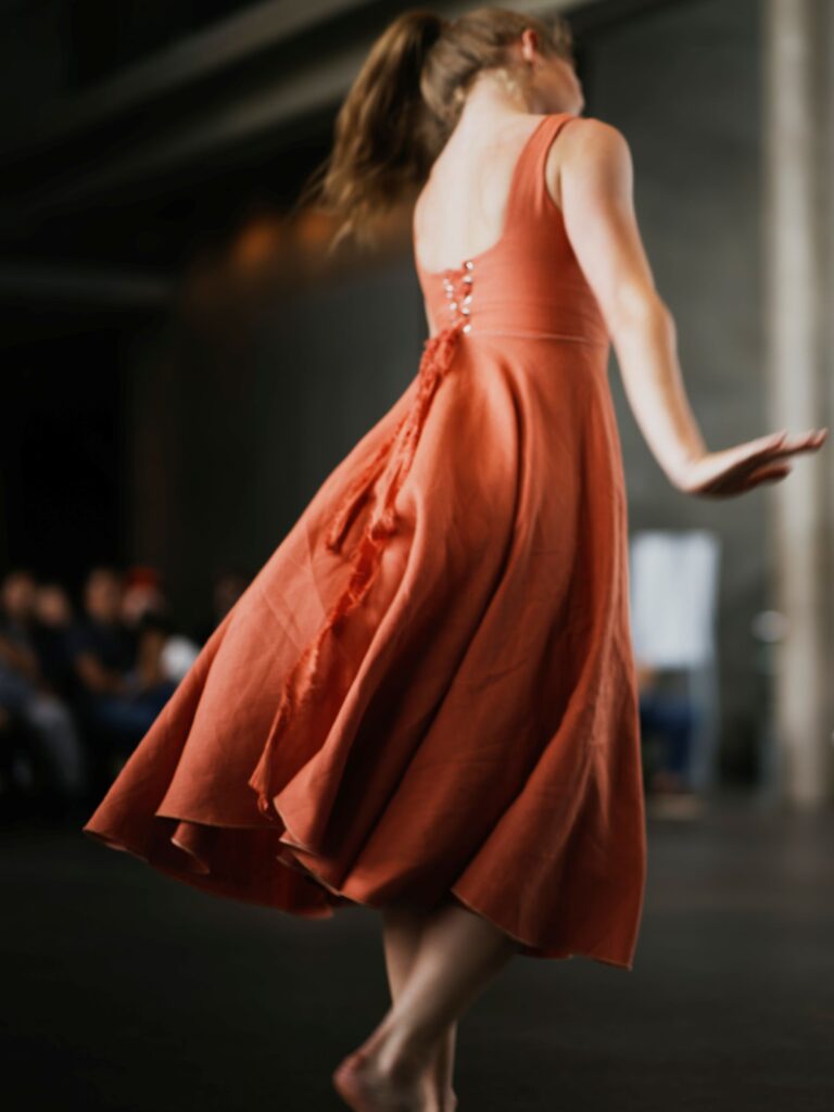 An image of a woman dancing in a dress by Ted Forbes.