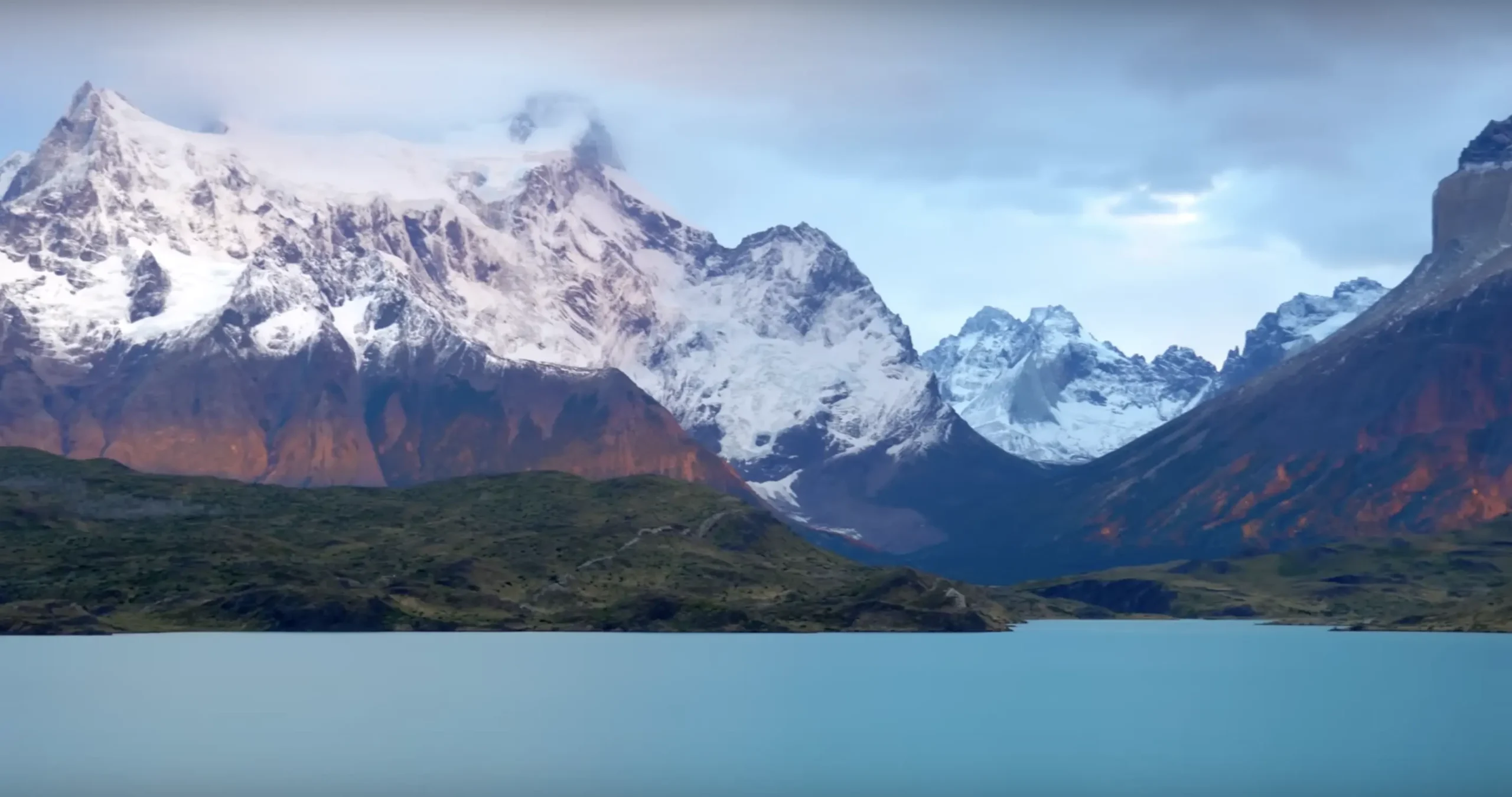 Dramatic landscape view of lake and mountain range in the background.