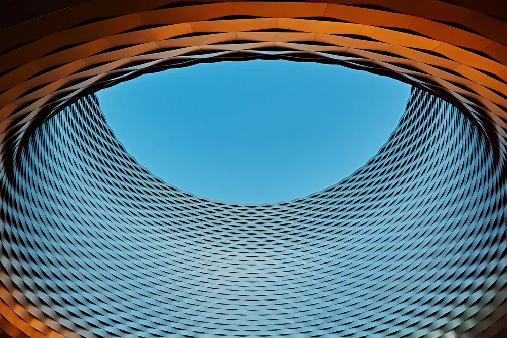 Abstract view of ring-shaped architectural feature, high-angle perspective. Upwards shot through hole-like structure in building, abstract architectural photography.