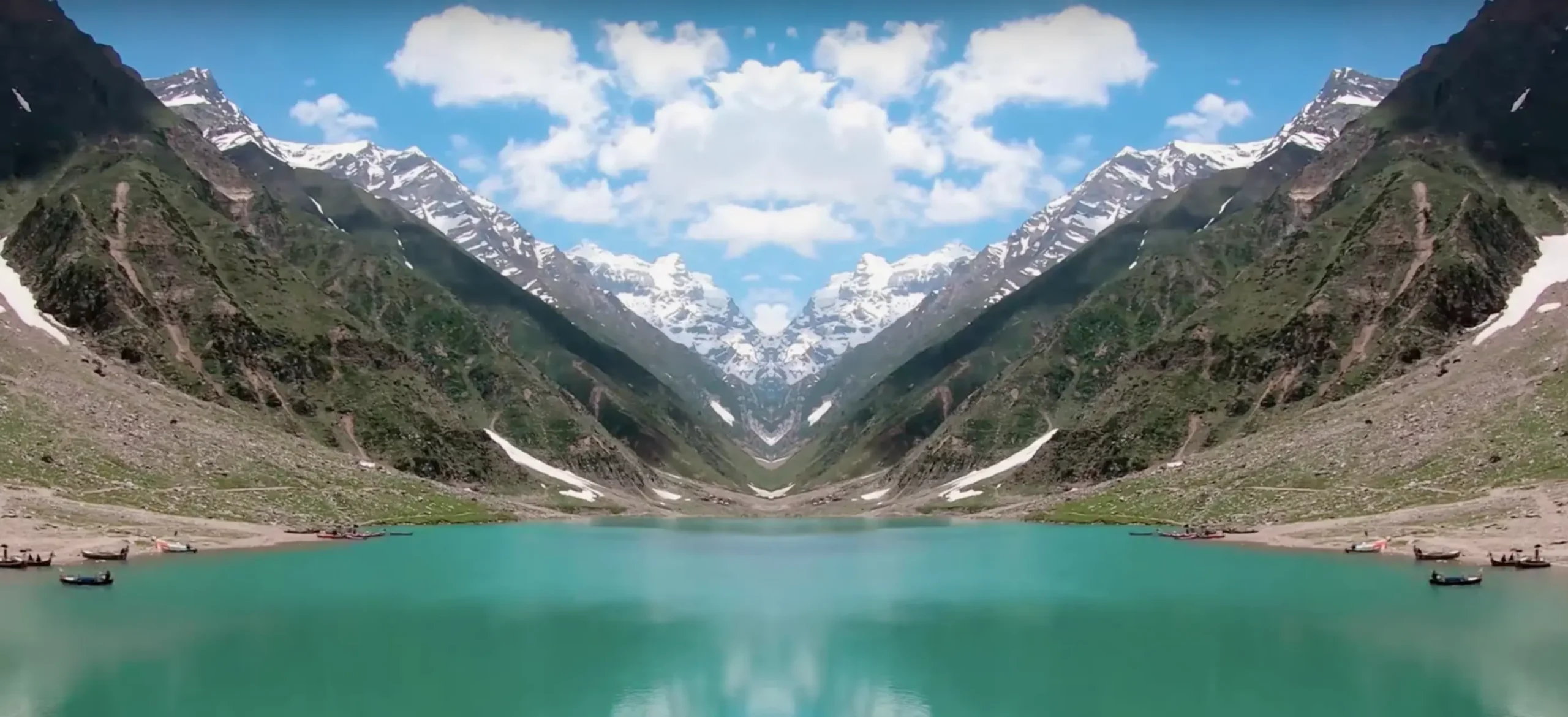 A beautiful lakeside landscape view with tall mountaintops.