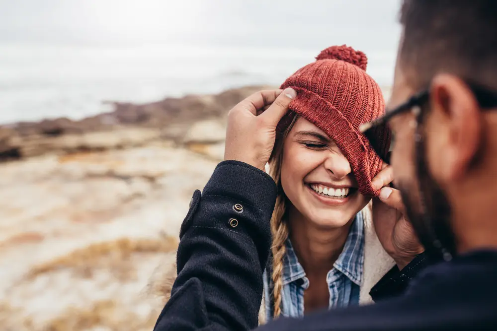 Candid moment of playfulness between adult couple. Sharing a laugh, couples photography in a candid, emotional style.