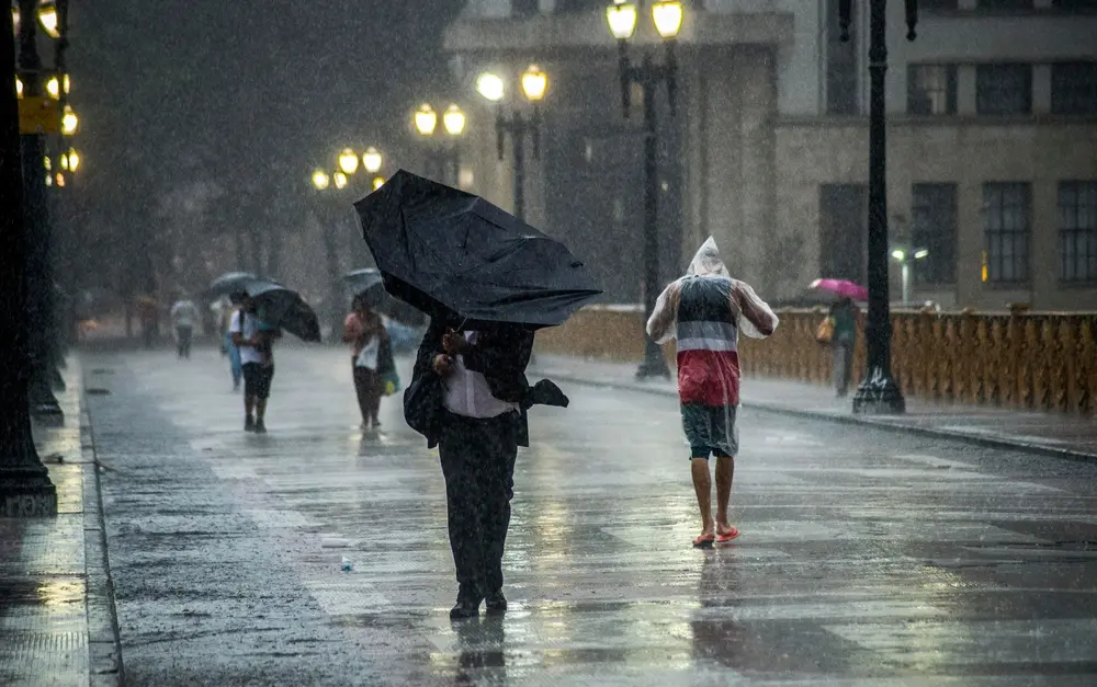 Heavy rain upsetting commuters in a big city boulevard. Street photography with action and fast motion.