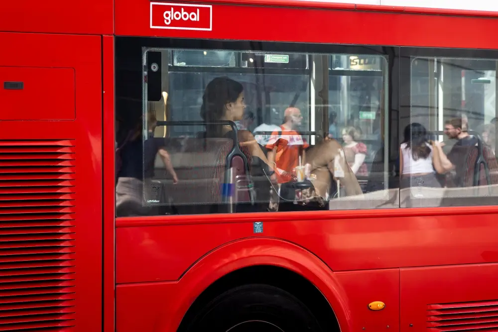 Young woman sitting on London double-decker bus. Daytime street photography of everyday life.