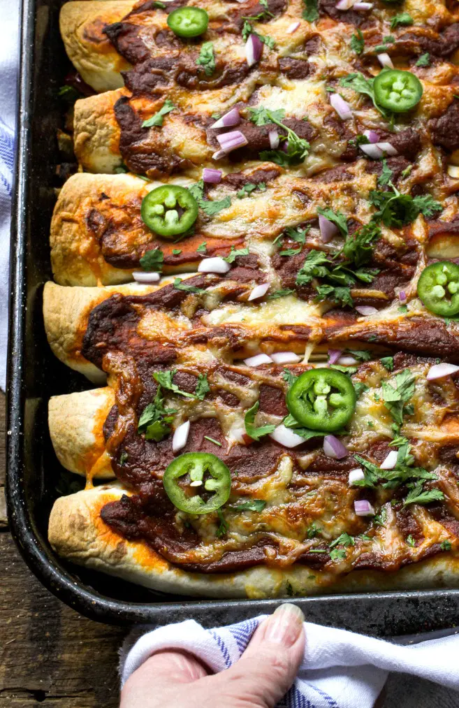 Overhead view of enchiladas in a baking pan.