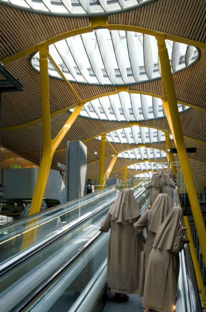 An image of the interior of the a build from an escalator with robed figures in front by Duccio Malagamba.