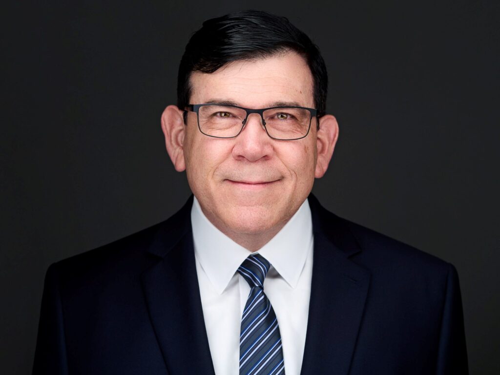 A headshot of a man in a suit by Jon Meadows