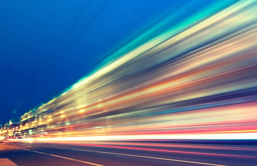 Motion blur photography exhibiting abstract depiction of speed and time flow during late-night traffic. Avant-garde photography in color using motion blur.