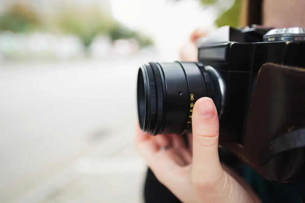 Close-up of old film SLR camera during a street photography session.