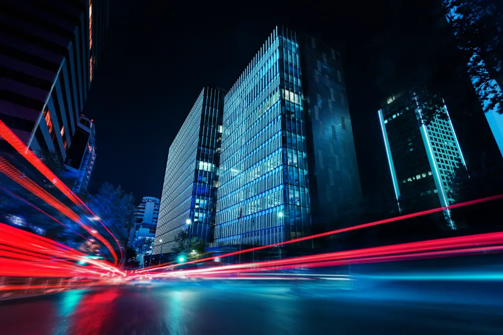 Light trail photography at night. Inner city traffic creating trails of red light contrasted against skyscrapers.