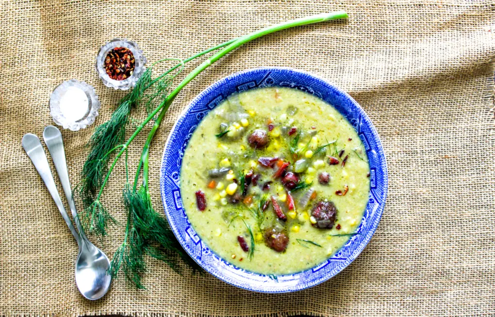 Overhead view of a blue bowl filled with vegetable soup.