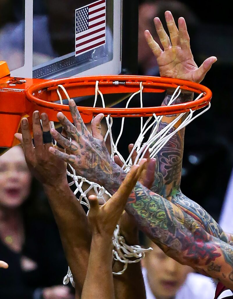 An image of a basketball net surrounded by hands by Chris Covatta.