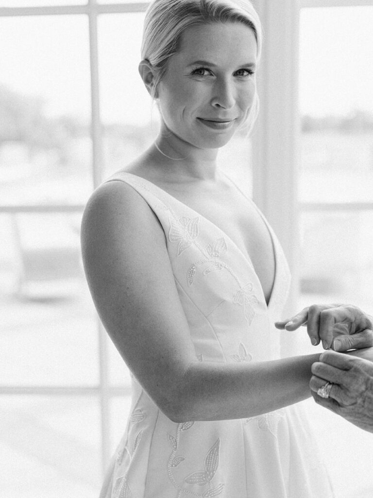 An image of a woman smiling while getting ready for a wedding by Hannah Bjorndal.