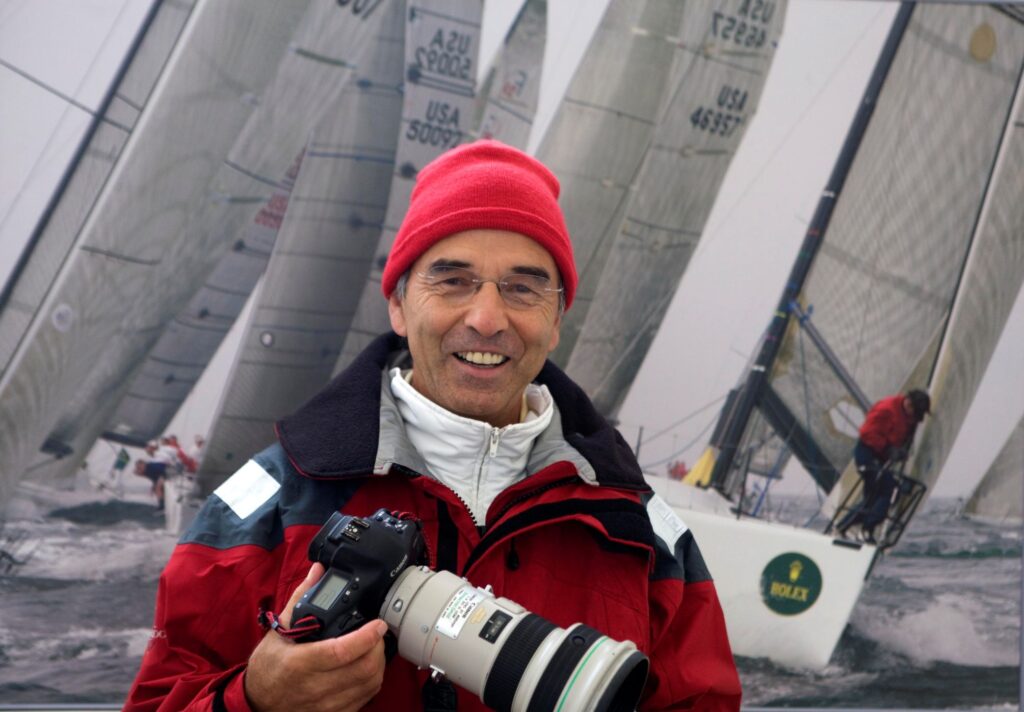 A headshot of Daniel Forster in front of some sail boats.