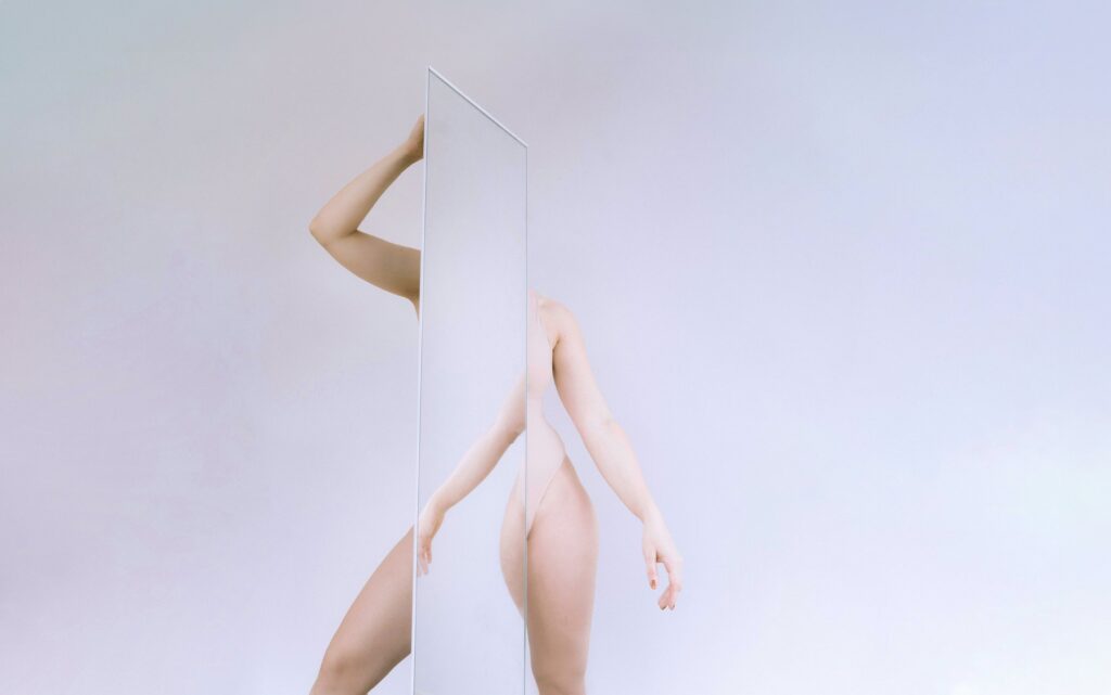 An abstract photo of a woman posing with a mirror by Laura Zalenga
