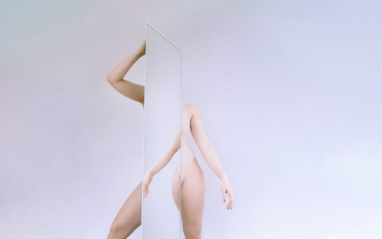 An abstract photo of a woman posing with a mirror by Laura Zalenga