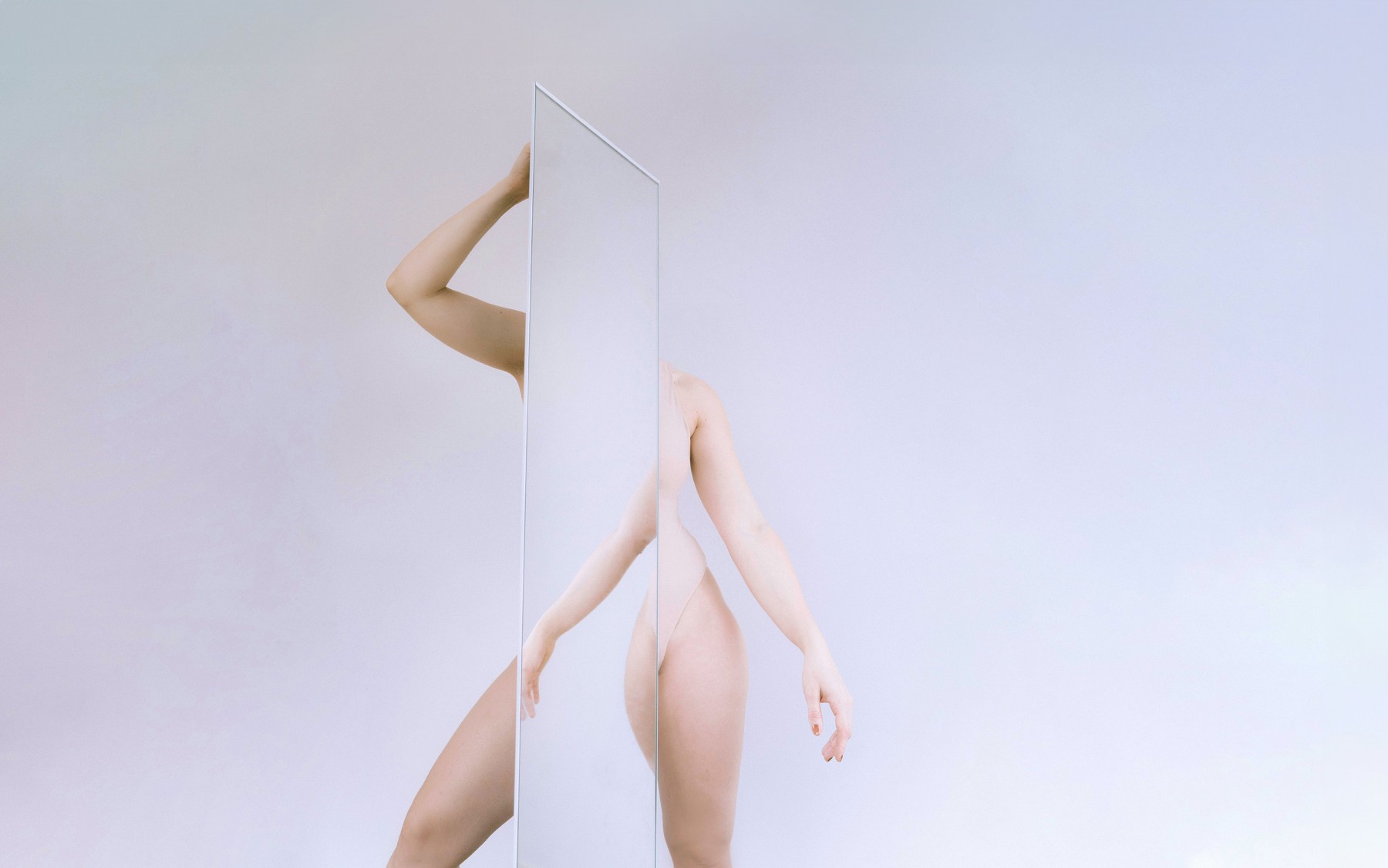 An abstract photo of a woman posing with a mirror by Laura Zalenga