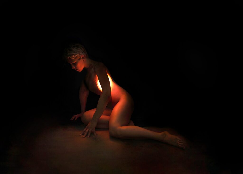 An image of a person laying half on the ground while a light grows in their ribcage by Laura Zalenga.
