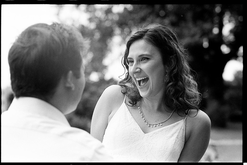 A black and white image of a woman smiling authentically, photographed by Johnny Martyr.