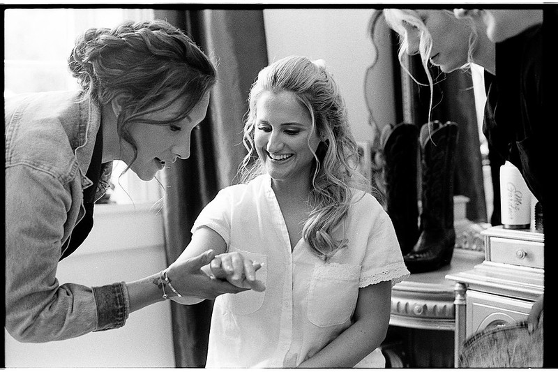 A photograph of several women admiring a ring on one of the fingers by Johnny Martyr.