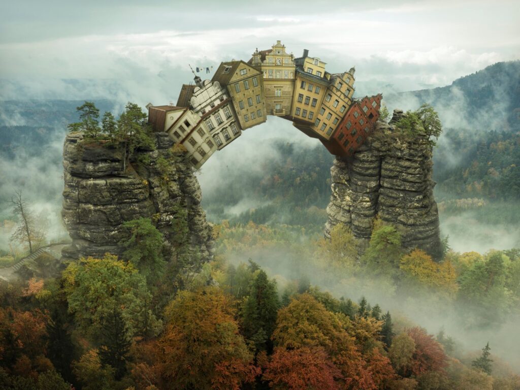 A surreal image of houses holding each other up between two rocky pillars by Erik Johansson.