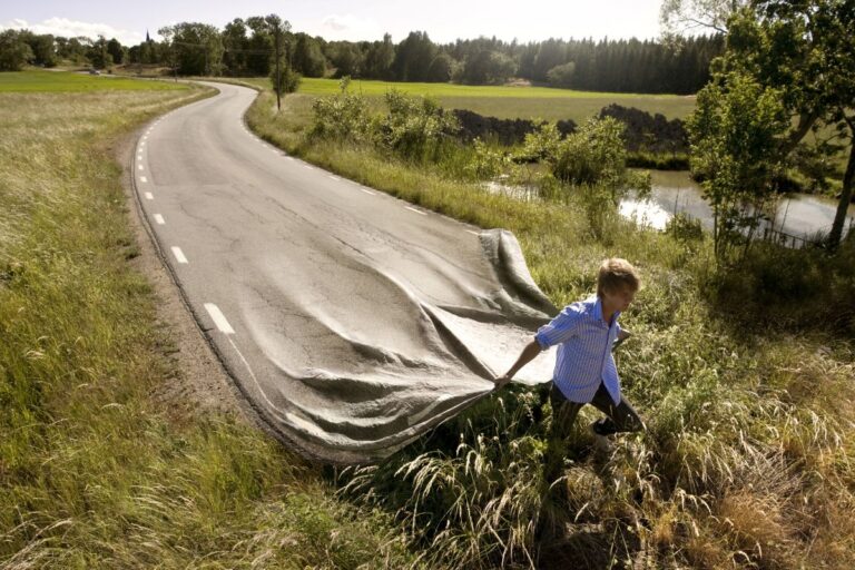 A surreal image of a man dragging a road behind him by Erik Johansson.