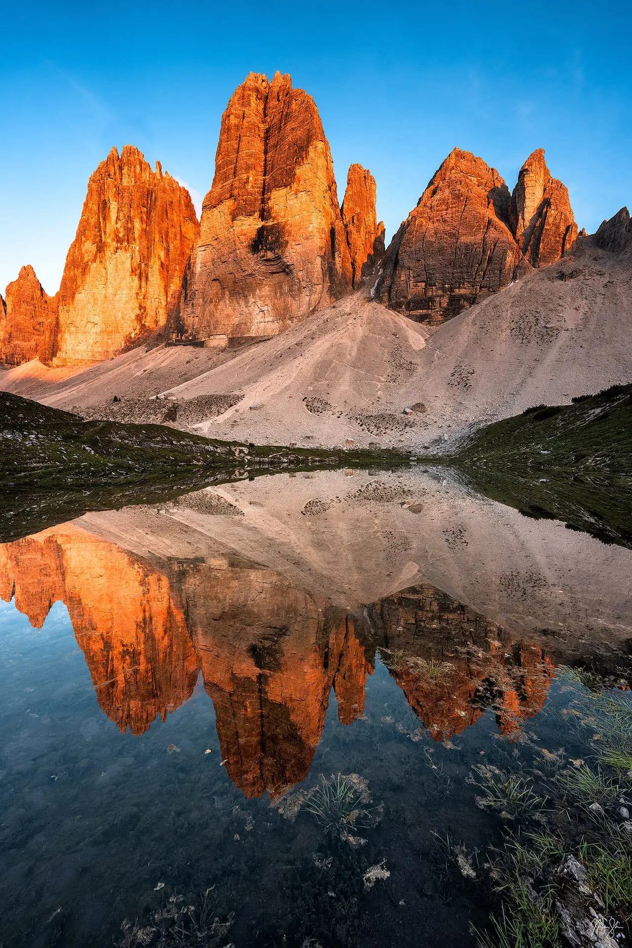 Alpenglow reflecting on Tre Cime di Lavaredo in the Dolomites at sunset.
