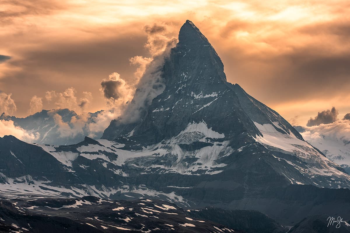 Dramatic sunset clouds swirling around the peak of the Matterhorn in Switzerland.