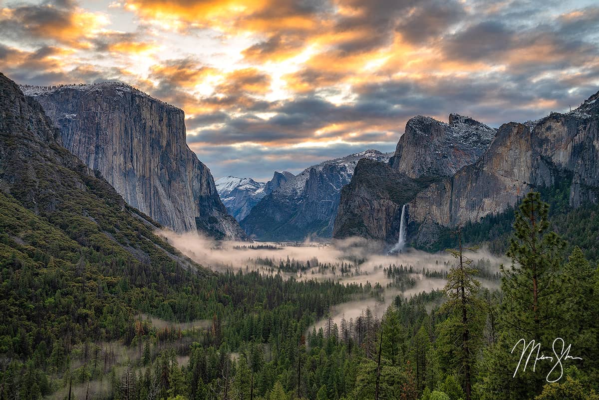 Sunrise clouds and low fog drifting through Yosemite Valley with El Capitan and Bridalveil Fall.