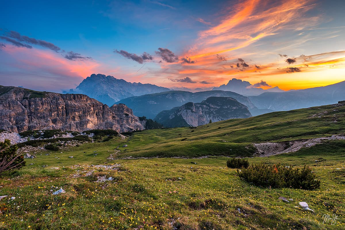 Sunset over the Dolomites with colorful clouds and mountain layers.