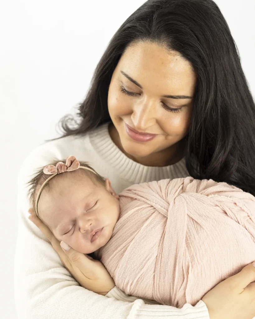 An image of a mother holding her newborn by Brittany DeMaio.