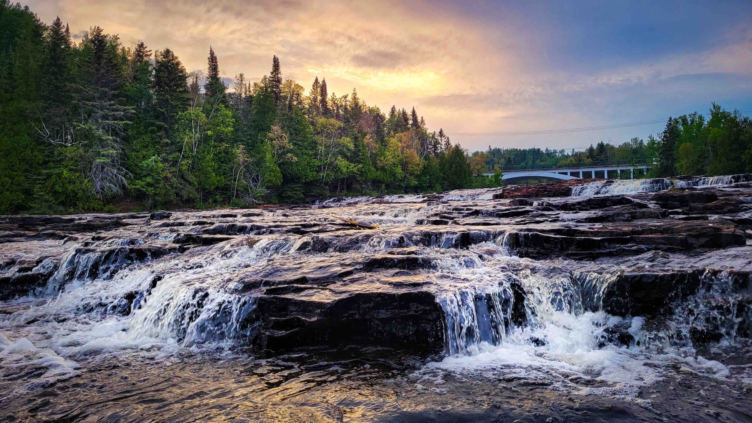 Blue hour light over a rocky river waterfall at dusk.