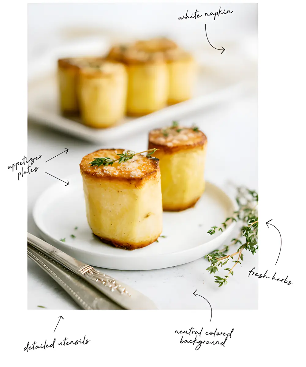 example of baked potatoes styled on a small plate with fresh herbs, a napkin, and vintage utensils against a neutral backdrop.