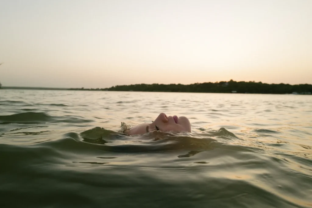 A photograph of a woman's face floating in a lake by Erich McVey.