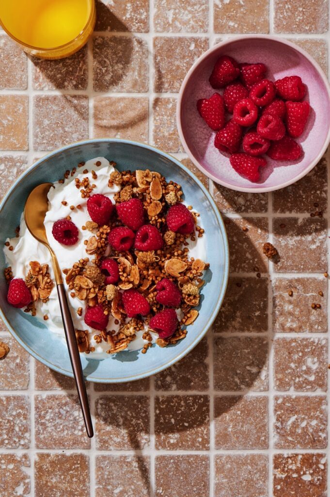 An image of some delicious granola with raspberries by Rachel Korinek.