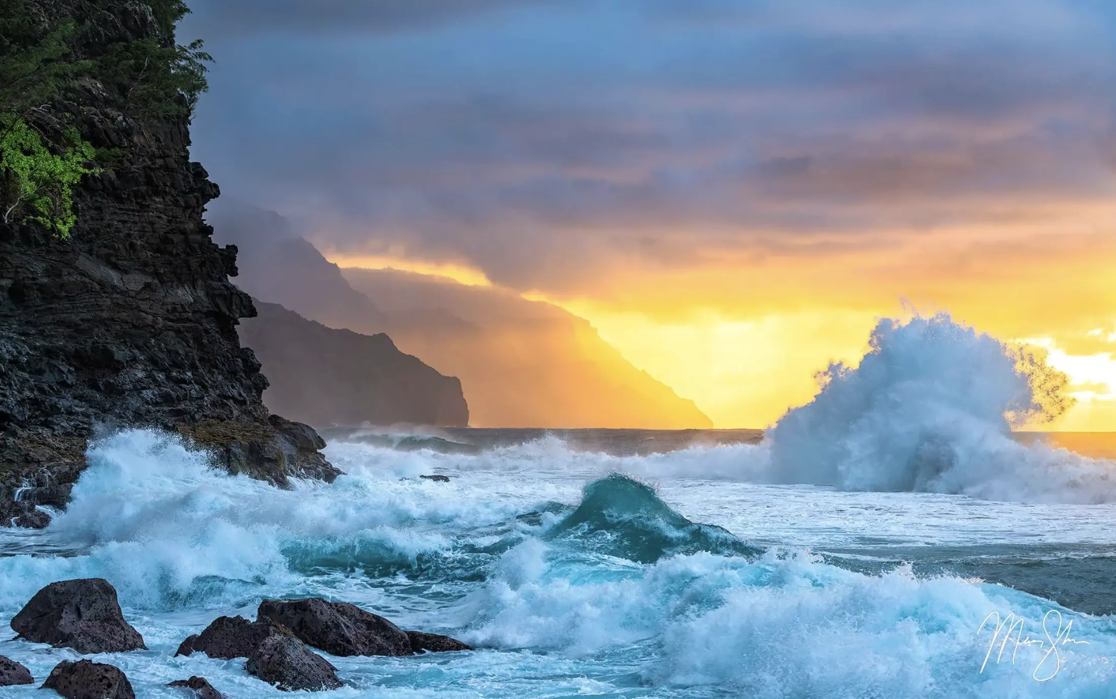 Powerful ocean waves crashing against rocky cliffs at sunset with dramatic clouds and golden light.