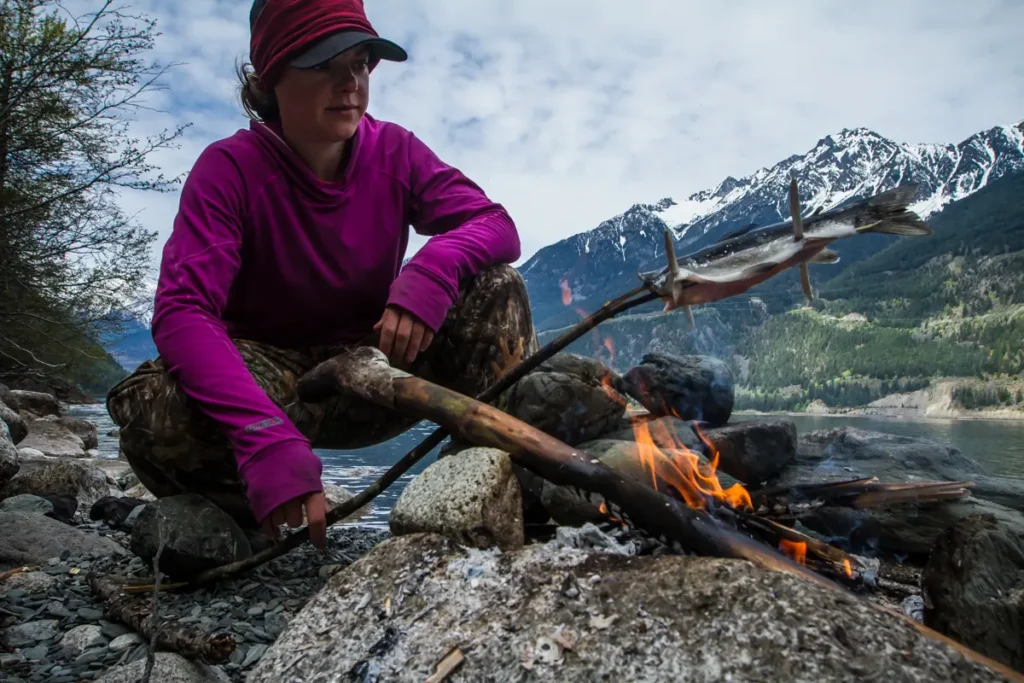 An image of Jillian Brown starting a fire in the wilderness.