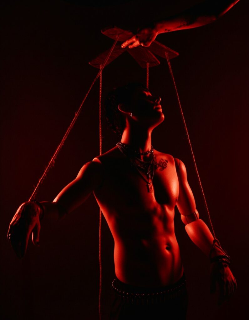 An image of a man bathed in red light being portrayed as a puppet by Sin City Creative.