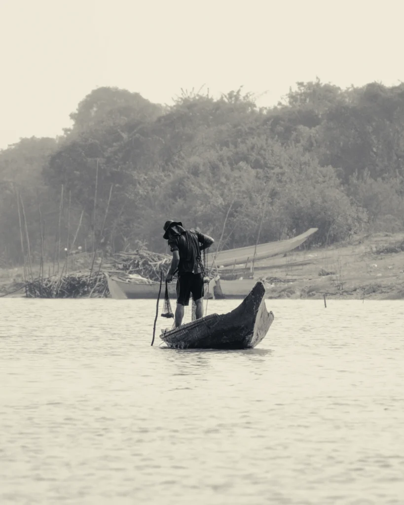 A photograph of a lone fisherman on a boat by Paulie Marechal.