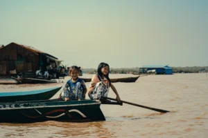 A photograph of two sisters in a boat by Paulie Marechal.