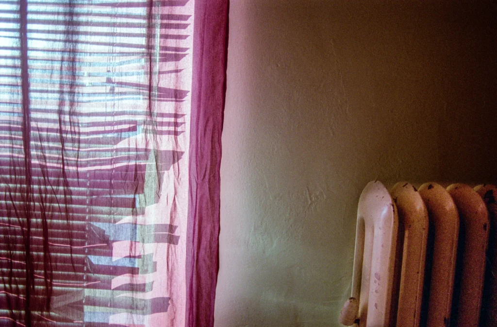 An image of lighting spilling from behind some curtains into a room by Ben Smith.