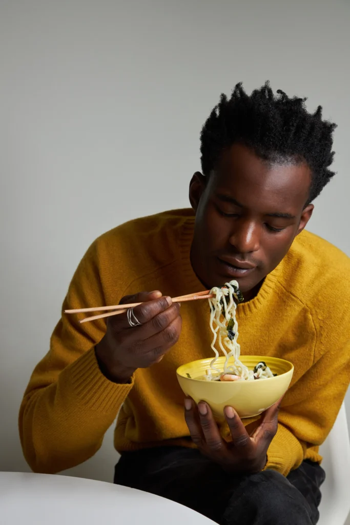 A portrait of a model eating ramen by Shelly Waldman.