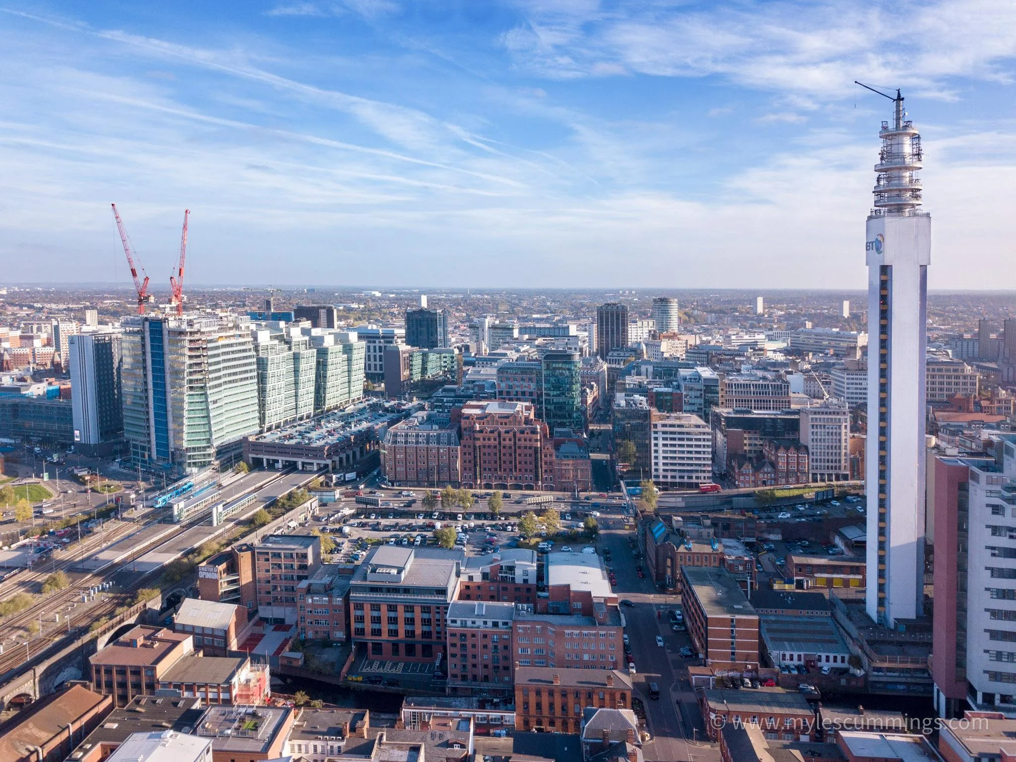 Aerial view of a city skyline with a tall landmark tower under blue sky