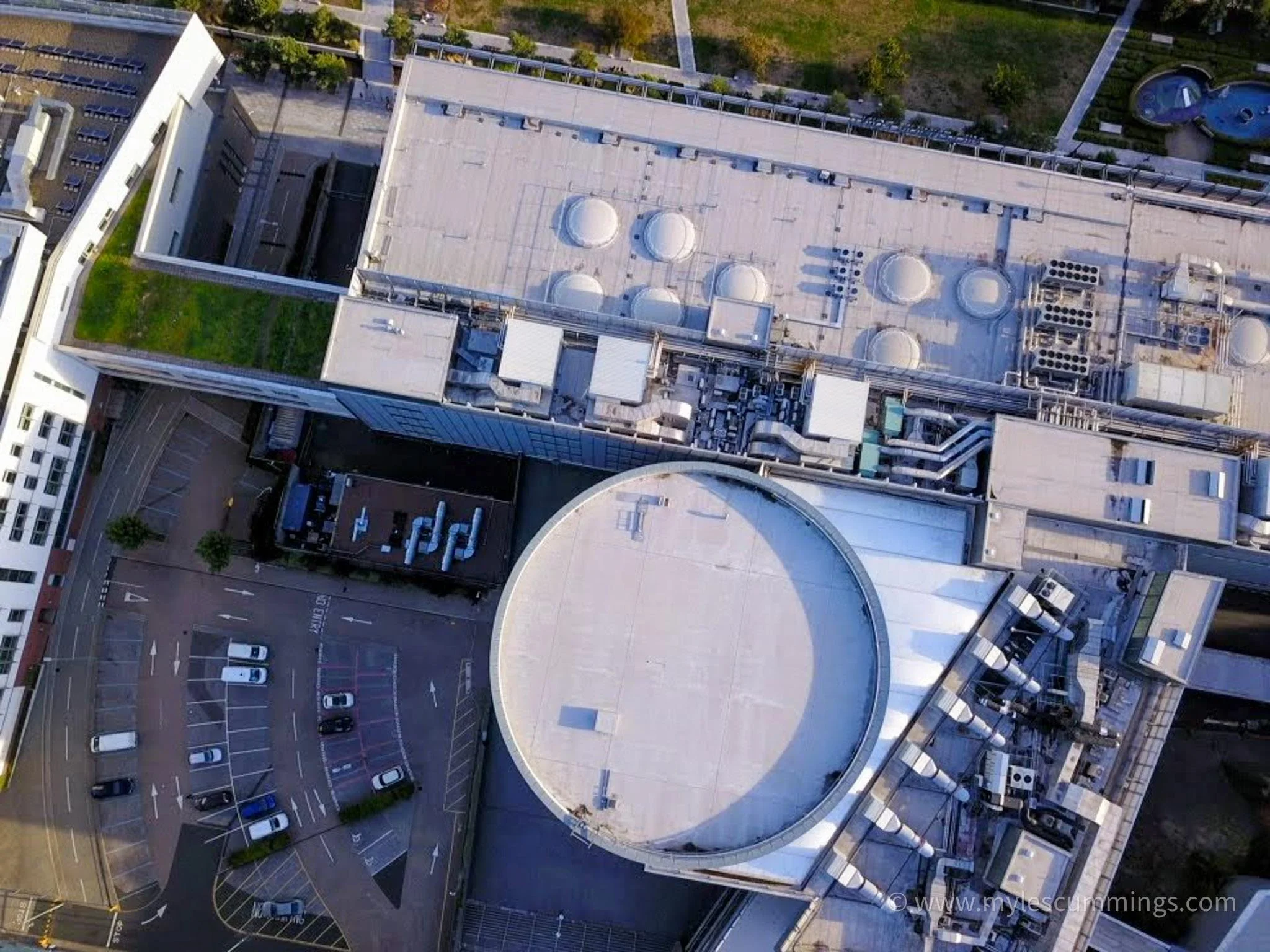 Top-down aerial view of circular industrial storage tanks and rooftops