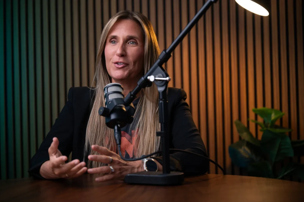A photograph of a person sitting behind a microphone shot by Daniel Wakefield.