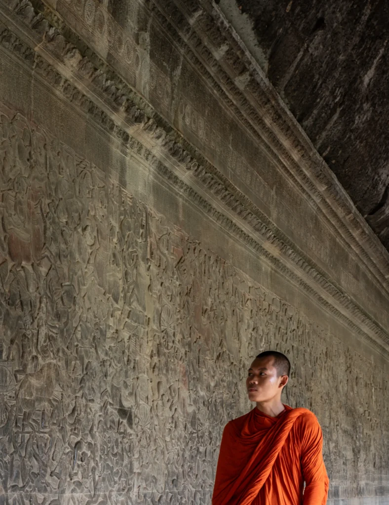 An image of a monk staring at depictions on a stone wall by Ronan O'Connell
