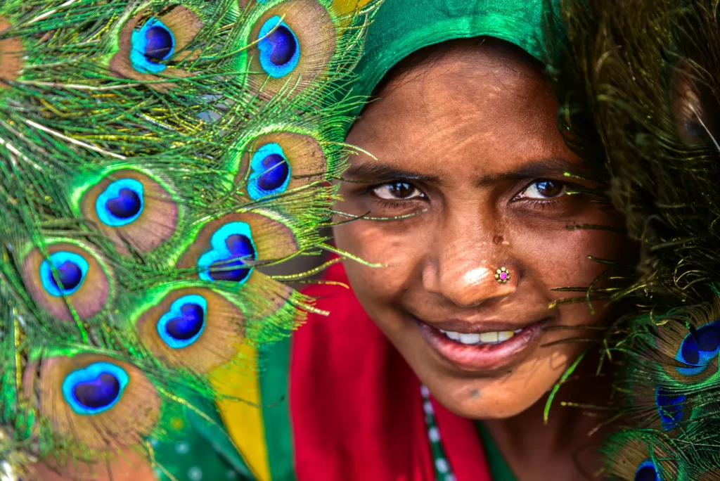An image of a woman posing by a peacock feather by Ronan O'Connell.