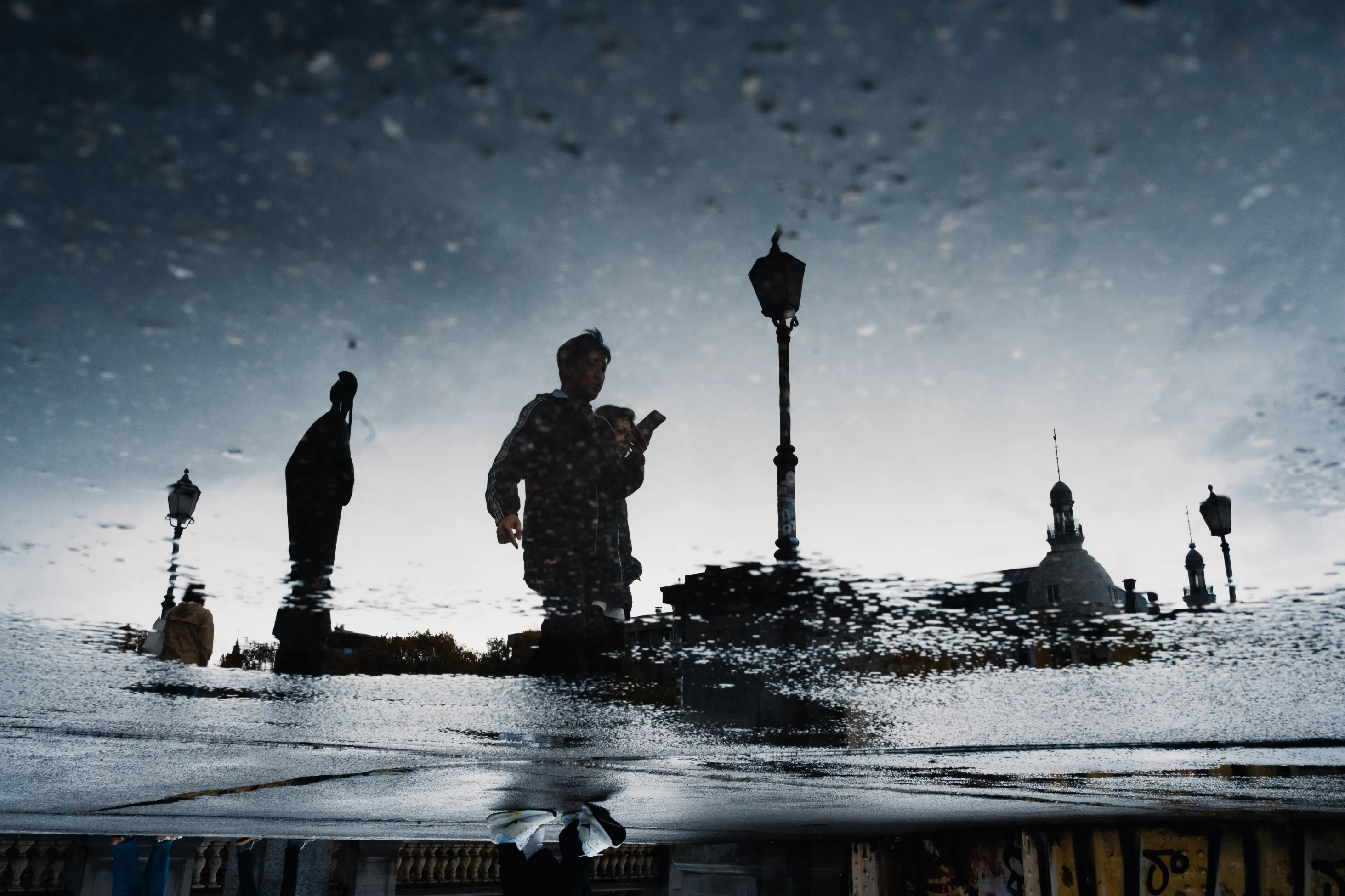 A street photography image of a reflection in a puddle by Frederic Paulussen